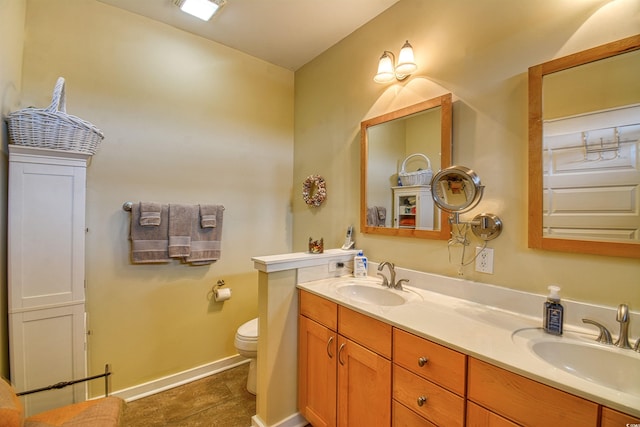 bathroom with double vanity, toilet, baseboards, and tile patterned flooring