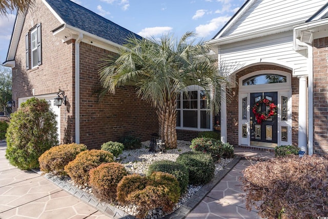 4608 Grovecrest Cir N, Myrtle Beach, SC 29582 - property entrance with brick siding, a garage, and a shingled roof
