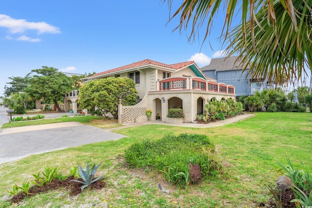 807 N Waccamaw Dr, Murrells Inlet, SC 29576 - mediterranean / spanish-style home with a balcony, brick siding, a front lawn, and a tile roof