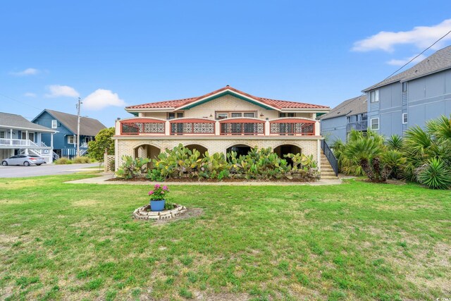 807 N Waccamaw Dr, Murrells Inlet, SC 29576 - mediterranean / spanish house featuring stairs, a front lawn, a balcony, and brick siding