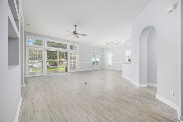 9831 Winchester Ct, Murrells Inlet, SC 29576 - unfurnished living room with ceiling fan, ornamental molding, a textured ceiling, wood finished floors, and arched walkways
