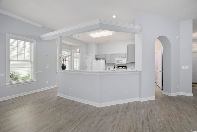 9831 Winchester Ct, Murrells Inlet, SC 29576 - unfurnished living room featuring wood finished floors, healthy amount of natural light, and arched walkways
