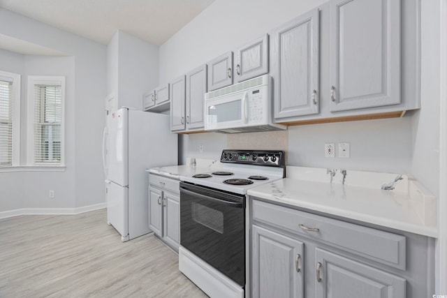 9831 Winchester Ct, Murrells Inlet, SC 29576 - kitchen featuring white appliances, light wood-style flooring, light countertops, and gray cabinets