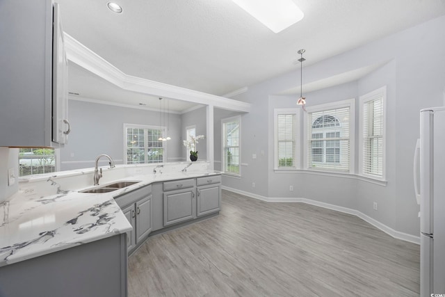 9831 Winchester Ct, Murrells Inlet, SC 29576 - kitchen with gray cabinetry, freestanding refrigerator, decorative light fixtures, light wood-style floors, and crown molding