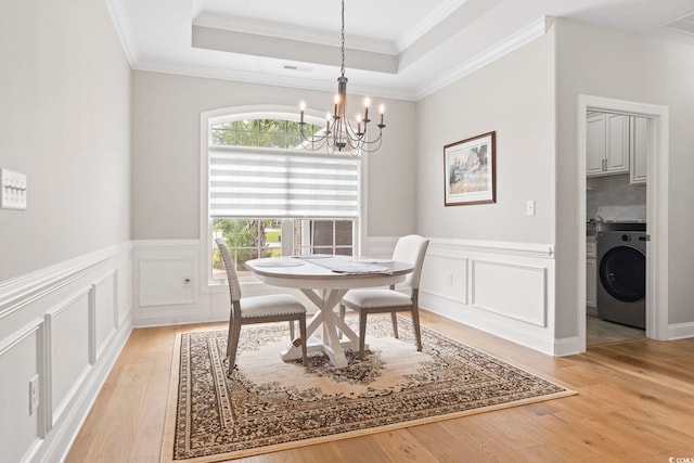 2204 Woodstork Dr, Conway, SC 29526 - dining room with washer / clothes dryer, a chandelier, light wood finished floors, crown molding, and a raised ceiling