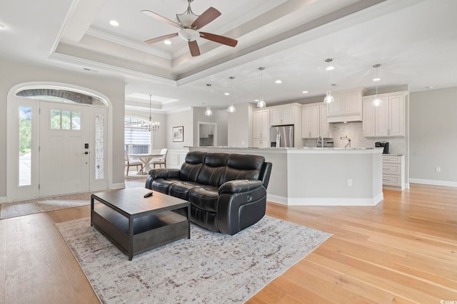 2204 Woodstork Dr, Conway, SC 29526 - living room with a tray ceiling, crown molding, light wood-type flooring, a chandelier, and a ceiling fan