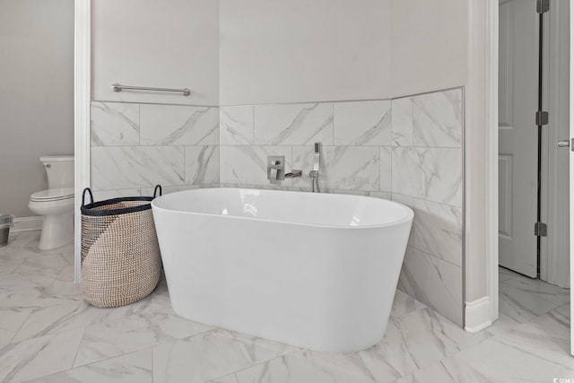 2204 Woodstork Dr, Conway, SC 29526 - bathroom featuring marble look tile flooring, tile walls, a soaking tub, toilet, and wainscoting