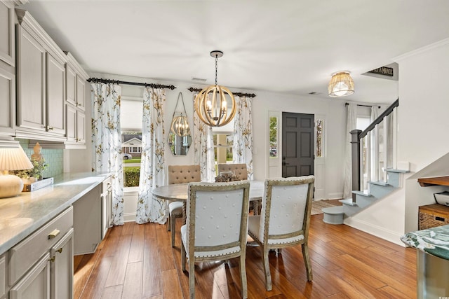 2170 Deerfield Ave, Surfside Beach, SC 29575 - dining area with a chandelier, stairway, light wood-style flooring, baseboards, and ornamental molding