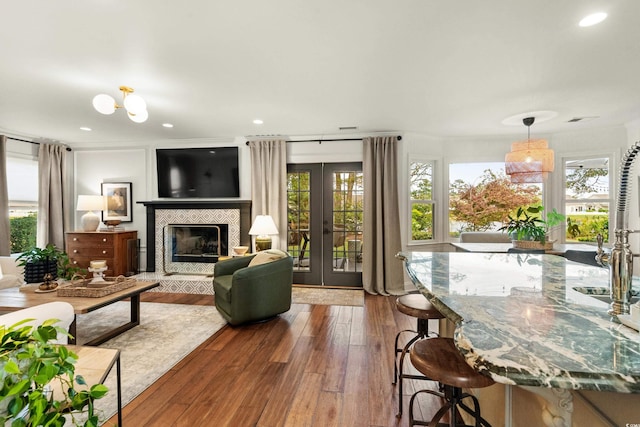 2170 Deerfield Ave, Surfside Beach, SC 29575 - living room with french doors, wood-type flooring, a tile fireplace, and recessed lighting