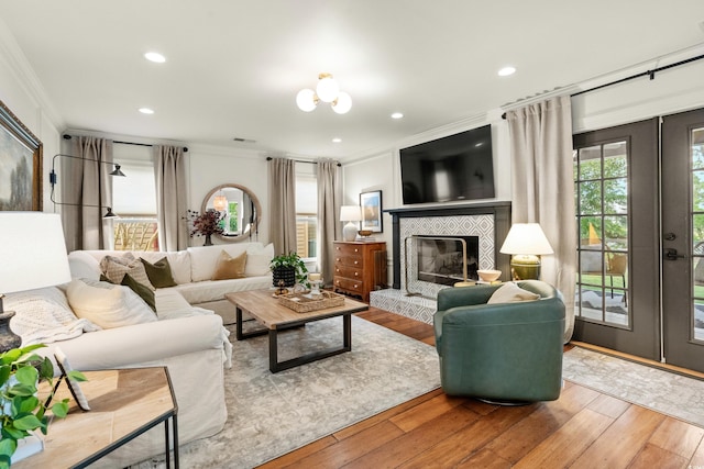 2170 Deerfield Ave, Surfside Beach, SC 29575 - living room featuring ornamental molding, hardwood / wood-style flooring, french doors, a tiled fireplace, and recessed lighting