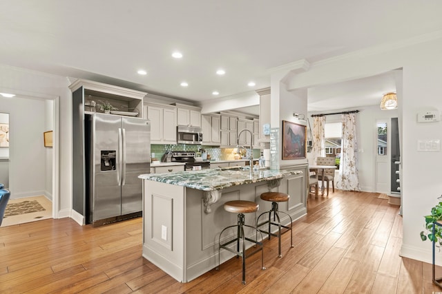 2170 Deerfield Ave, Surfside Beach, SC 29575 - kitchen featuring stainless steel appliances, a sink, crown molding, a breakfast bar, and light wood-style flooring