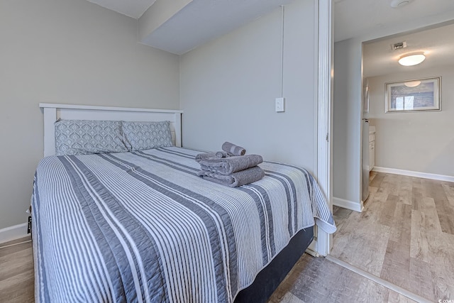 bedroom with wood finished floors and baseboards