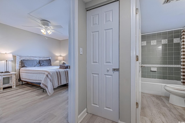 bedroom with light wood-style flooring, connected bathroom, ceiling fan, and baseboards