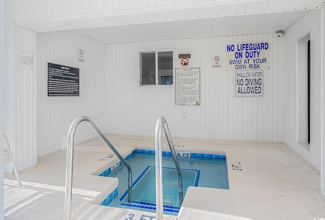 view of swimming pool featuring a hot tub
