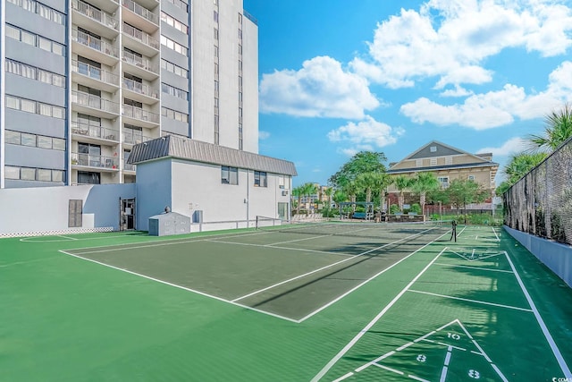 view of tennis court featuring shuffleboard and fence