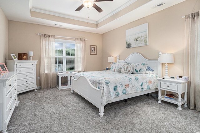 bedroom with crown molding, carpet flooring, a tray ceiling, and ceiling fan