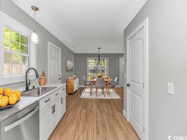23 Gabe Pl, Pawleys Island, SC 29585 - kitchen with dishwasher, a sink, light wood finished floors, white cabinetry, and light countertops