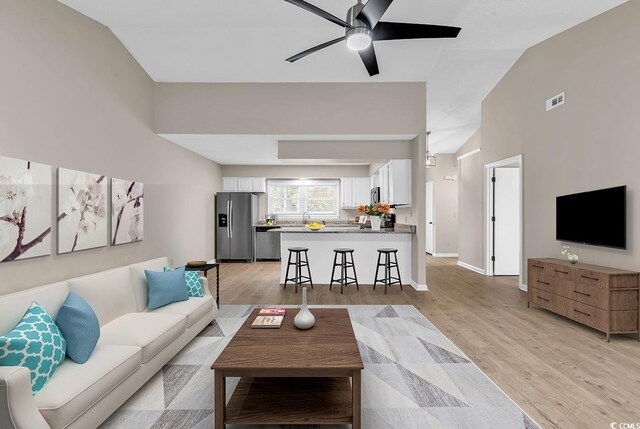 4339 Baldwin Ave Unit 4339, Little River, SC 29566 - living area featuring vaulted ceiling, ceiling fan, light wood-type flooring, and baseboards