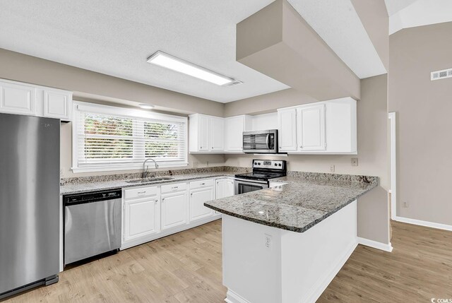 4339 Baldwin Ave Unit 4339, Little River, SC 29566 - kitchen featuring stainless steel appliances, a sink, light wood finished floors, and a peninsula