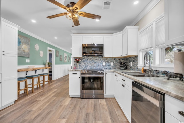 1014 Thomas Ave, North Myrtle Beach, SC 29582 - kitchen with stainless steel appliances, a sink, ornamental molding, white cabinetry, and a ceiling fan