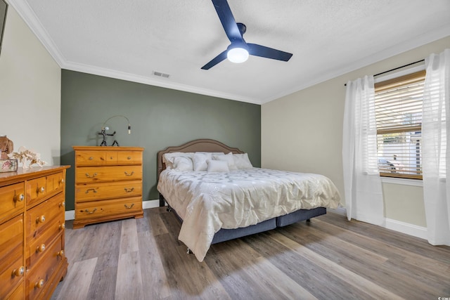 1014 Thomas Ave, North Myrtle Beach, SC 29582 - bedroom with wood finished floors, baseboards, crown molding, a ceiling fan, and a textured ceiling