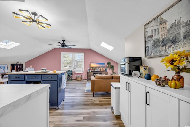 1014 Thomas Ave, North Myrtle Beach, SC 29582 - kitchen with a skylight, blue cabinetry, light wood-style floors, open floor plan, and light countertops