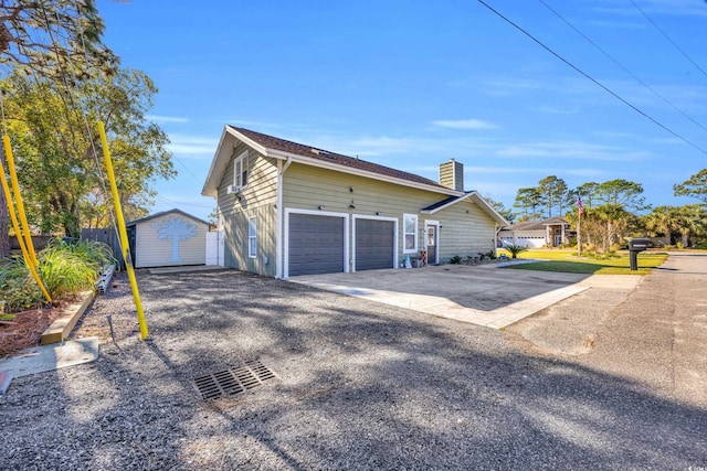 1014 Thomas Ave, North Myrtle Beach, SC 29582 - view of property exterior with a chimney, concrete driveway, an attached garage, a storage unit, and an outbuilding
