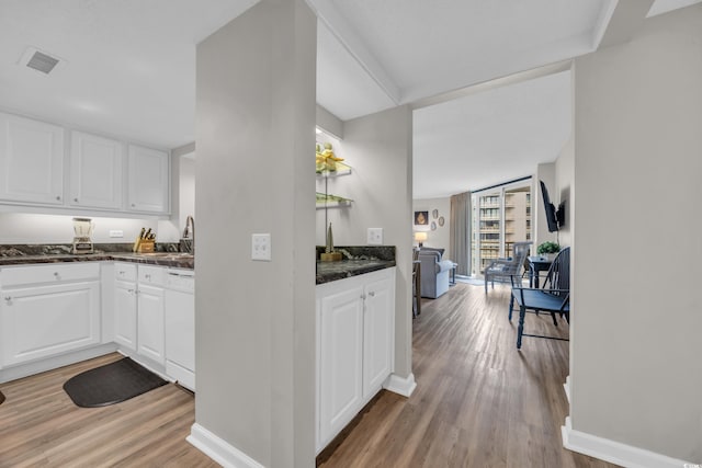 kitchen featuring light wood finished floors, baseboards, and white cabinets