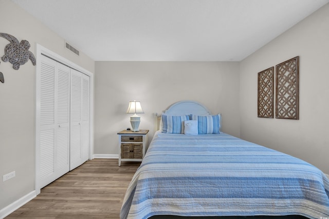 bedroom featuring wood finished floors, baseboards, and a closet