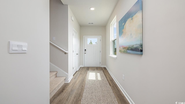 doorway featuring wood finished floors, stairs, baseboards, and recessed lighting