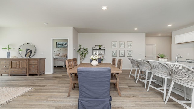 dining area featuring light wood-type flooring, recessed lighting, and baseboards