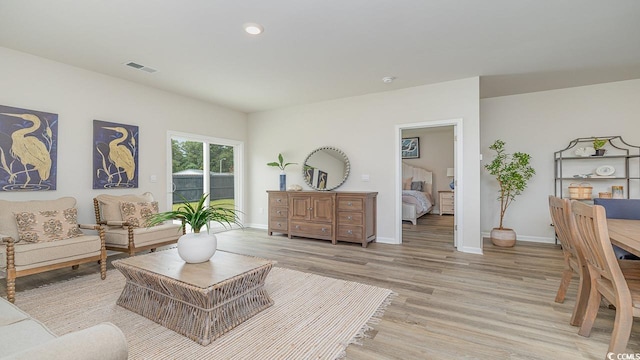 living area with light wood-style floors, baseboards, and recessed lighting