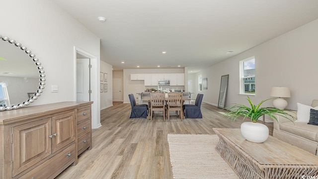 living room featuring light wood-type flooring, recessed lighting, and baseboards