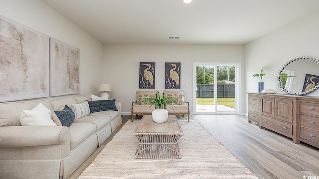 living room featuring light wood-type flooring, recessed lighting, and baseboards