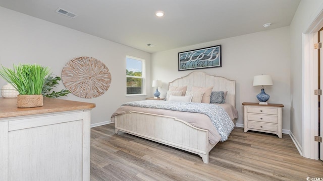 bedroom featuring wood finished floors, baseboards, and recessed lighting