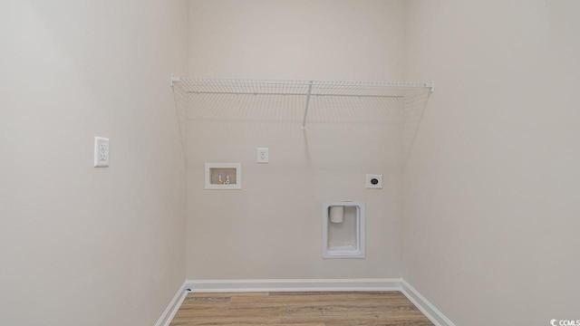 clothes washing area with electric dryer hookup, hookup for a washing machine, light wood-style flooring, and baseboards