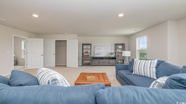 living room featuring light colored carpet, recessed lighting, and baseboards