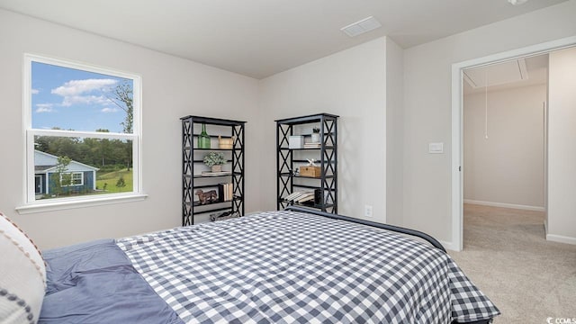 carpeted bedroom featuring attic access and baseboards