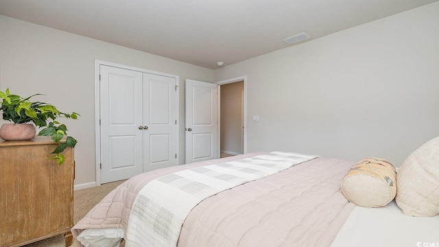 bedroom with carpet floors, baseboards, and a closet