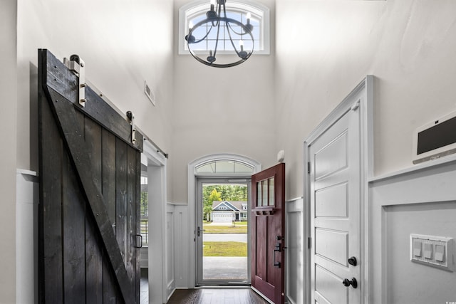 2909 Moss Bridge Ln, Myrtle Beach, SC 29579 - entrance foyer featuring a barn door, a chandelier, a high ceiling, and dark wood finished floors