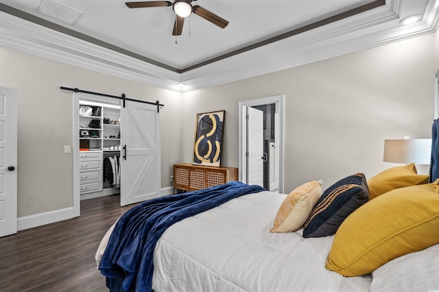 2909 Moss Bridge Ln, Myrtle Beach, SC 29579 - bedroom with a barn door, crown molding, wood finished floors, a walk in closet, and baseboards