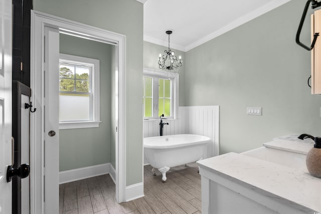 2909 Moss Bridge Ln, Myrtle Beach, SC 29579 - bathroom featuring a freestanding bath, wood finished floors, ornamental molding, a chandelier, and wainscoting