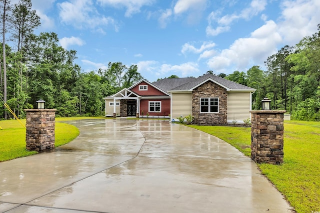 3995 Tillmond Dr, Conway, SC 29526 - craftsman house with stone siding, a front yard, curved driveway, and roof with shingles