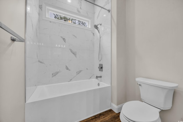 bathroom featuring toilet, wood finished floors, shower / tub combination, and baseboards