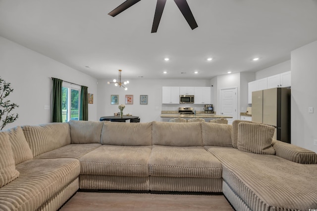 living area with a chandelier, recessed lighting, a ceiling fan, and light wood-style floors