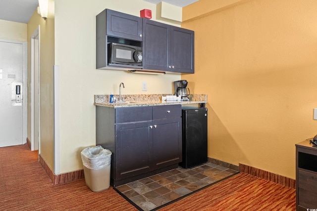 1501 S Ocean Blvd Unit 1231, Myrtle Beach, SC 29577 - kitchen featuring black microwave, refrigerator, a sink, and light stone countertops