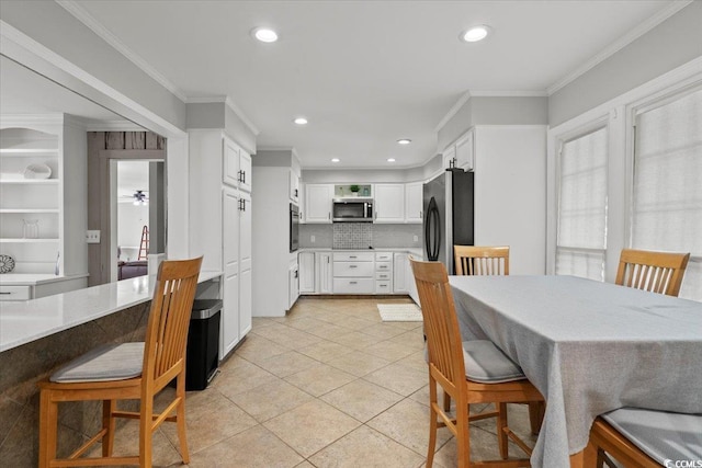 dining space with light tile patterned floors, crown molding, and recessed lighting