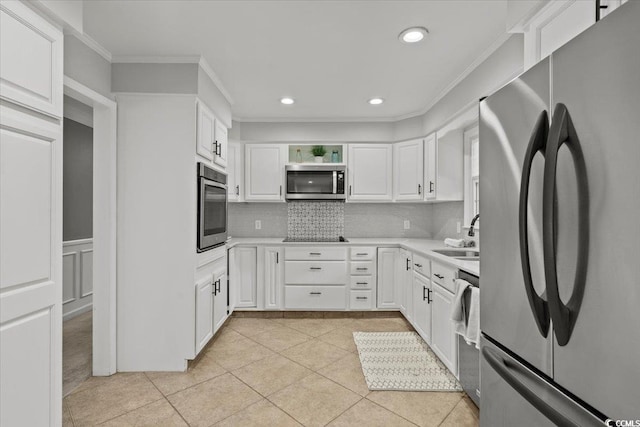 kitchen with appliances with stainless steel finishes, a sink, crown molding, backsplash, and light tile patterned flooring