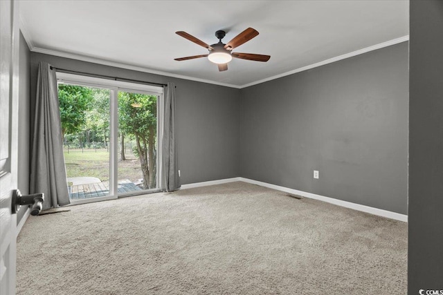 carpeted empty room featuring ornamental molding, ceiling fan, and baseboards