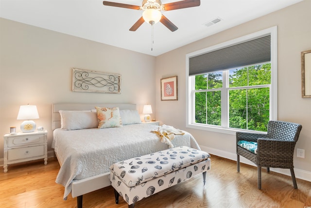 bedroom featuring baseboards, wood finished floors, and a ceiling fan